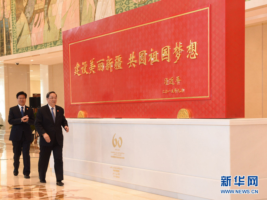 這是俞正聲和中共中央政治局委員、新疆維吾爾自治區黨委書記張春賢一同為習近平總書記題詞賀匾揭幕。新華社記者 高潔 攝 