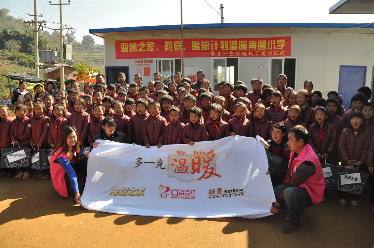 2014年11月20日，“多一克溫暖”公益團隊來到8.3大地震的重災區——云南省昭通市魯甸縣的南筐小學。越過崎嶇山路，將一批又一批暖心羽絨服送到了師生們的手中，也將社會的關懷和愛意傳遞給了這些可愛的人。
