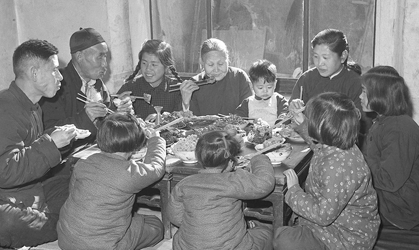 1953年春節(jié)天津漢沽區(qū)蘆臺王德鑄(左一)一家人吃團(tuán)圓飯(新華社稿)