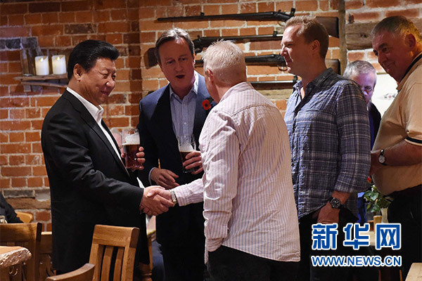 這是習(xí)近平與卡梅倫飲啤酒，并同當(dāng)?shù)孛癖娊徽劇Ｐ氯A社記者 饒愛民 攝